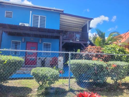 a blue house with a fence in front of it at Silverbuttons in Rat Island