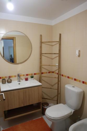 a bathroom with a toilet and a sink and a mirror at Art House Madeira I in Caniço