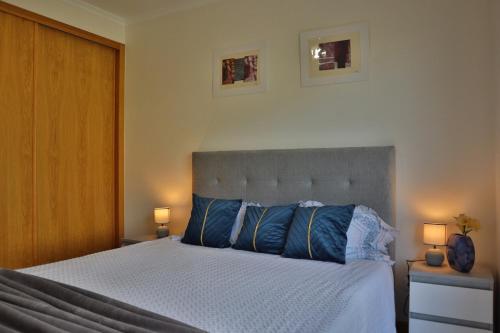 Un dormitorio con una cama grande con almohadas azules. en Art House Madeira I, en Caniço