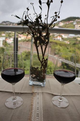 two glasses of red wine sitting on a table at Art House Madeira I in Caniço