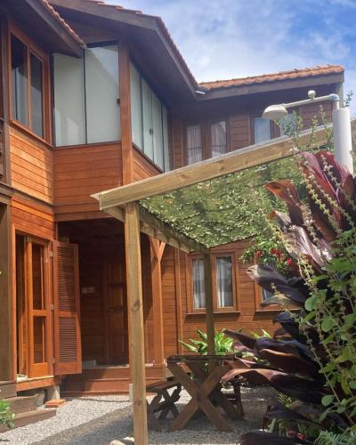 a wooden house with a picnic table in front of it at La Tatuira, Cabana Amarela in Pinheira