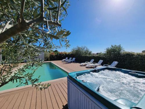 un bain à remous sur une terrasse à côté d'une piscine dans l'établissement Le Ranch, à Oupia