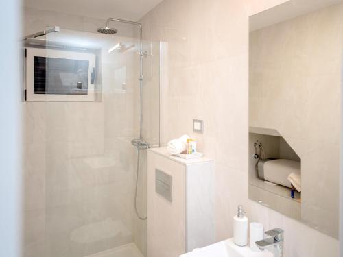 ein weißes Badezimmer mit Dusche und Waschbecken in der Unterkunft Nicely decorated house with top roofed terrace in Vrboska