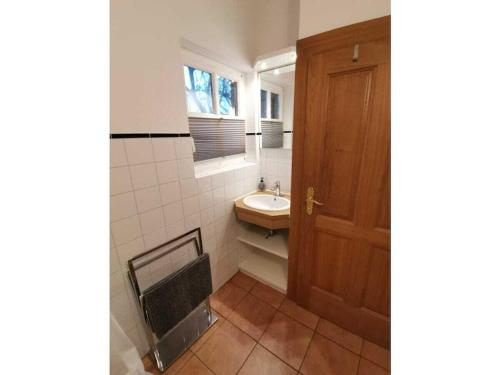 Un baño con lavabo y puerta de madera. en Grand Reverend Deichstern, en Großwürden