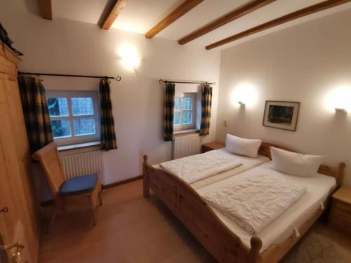 Un dormitorio con una cama y una silla dentro. en Grand Reverend Deichstern, en Großwürden