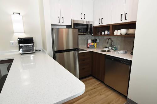 a kitchen with white cabinets and a stainless steel refrigerator at Staybridge Suites Detroit-Novi by IHG in Novi