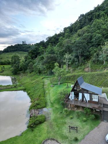 a house on a hill next to a river at Chale Bouganville Ituporanga JACUZZI in Ituporanga