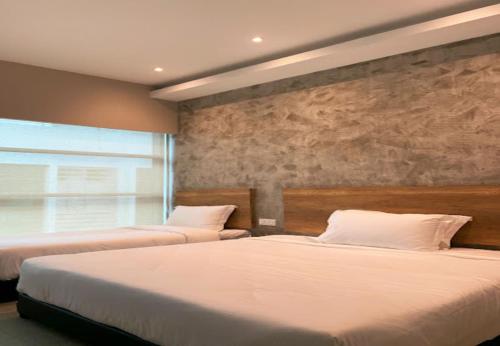 a bedroom with two beds and a large window at Saradise Point Stay in Kuching