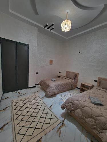 Zimmer mit 2 Betten und einem Kronleuchter in der Unterkunft Appartement In Ksar Ait Ben Haddou in Aït-Ben-Haddou