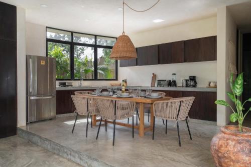 a kitchen with a wooden table and chairs in a kitchen at Bohemian Bliss Villa with Private Pool & Concierge 1A in Tulum