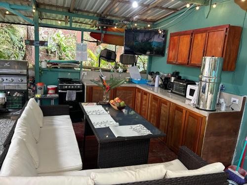 a kitchen with a couch and a table in a kitchen at Boutique Rooms River Front at La Junta in Dominical