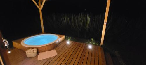 a bath tub on a wooden deck at night at Exclusivo Cocora con Jacuzzi Salento Quindio in Salento