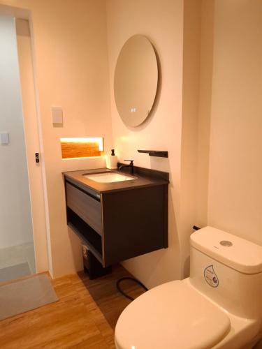 a bathroom with a toilet and a sink and a mirror at Boracay Luxury Apartments in Boracay