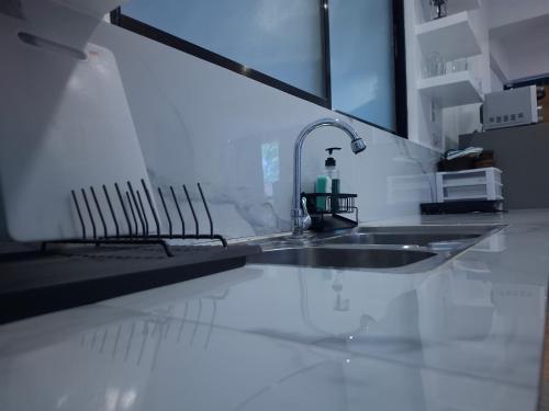 a kitchen counter with a sink and a mirror at Boracay Luxury Apartments in Boracay