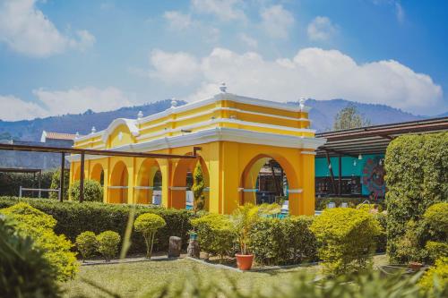 a yellow and white building with bushes in front of it at Elite Maya Hotel & Spa in Antigua Guatemala