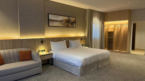 a hotel room with a bed and a chair at فندق آرام النسيم in Ash Shishah