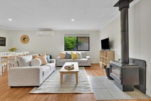 a living room with a couch and a fireplace at Briar Rose Cottages in Stanthorpe