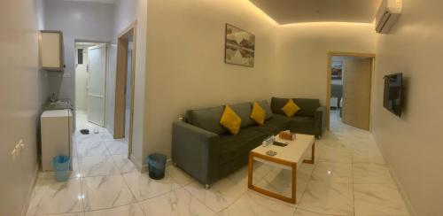a living room with a green couch and a table at skoon rest hotel in Hafr Al Baten