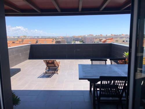 a patio with a table and chairs on a roof at Apartamento na Praia da Vagueira in Vagos