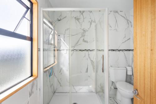 a bathroom with a shower and a toilet at Spacious modern executive home in Wellington