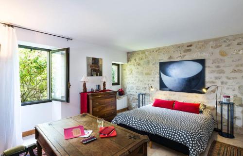 - une chambre avec un lit doté d'oreillers rouges et d'une table dans l'établissement OSHIDORi le Petit Manoir, à Monteton