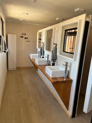 a bathroom with three sinks and two mirrors at Departamento Pacifico in Matanzas