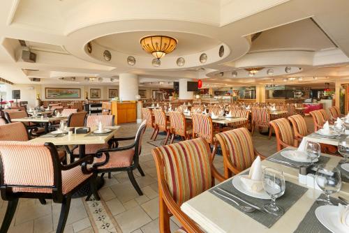 a dining room with tables and chairs in a restaurant at Regal Palace Hotel in Dongguan