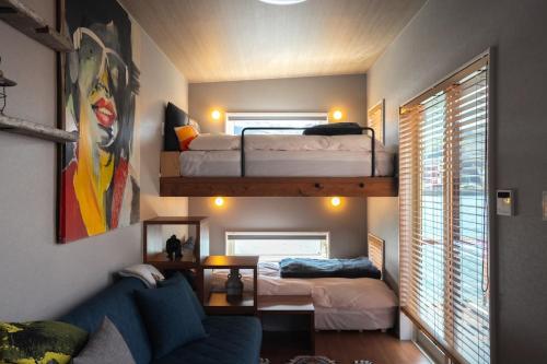 ein Zimmer mit zwei Etagenbetten und einer Couch in der Unterkunft Trailer inn Onomichi in Onomichi