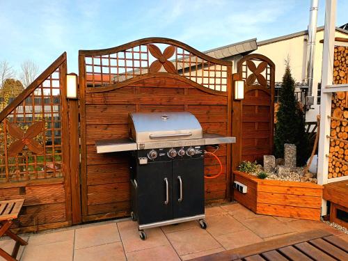 a grill on a patio with a wooden fence at Bussardhorst in Ruppichteroth
