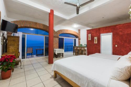 a bedroom with a bed and a view of the ocean at Traditional Sierra Leon Oceanfront Rooms - Adults Only in Puerto Vallarta