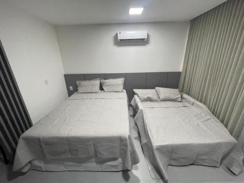 two beds in a small room with at Studio 306 Simple Manaira Excelente Localização in João Pessoa