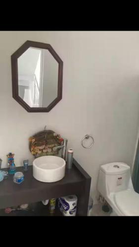 Un baño con un lavabo y un espejo en la pared. en Universidades & Unifut a la mano, en Tilcuautla