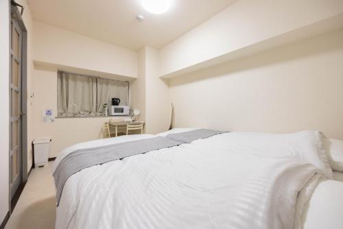 a bedroom with two white beds and a window at Minami-Fukuoka Good Place House in Fukuoka