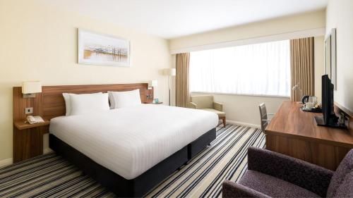 a hotel room with a bed and a desk at Holiday Inn Brighton Seafront by IHG in Brighton & Hove