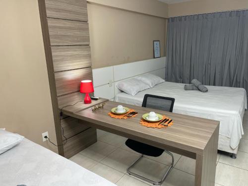 a room with two beds and a table with food on it at Suíte premium de alto padrão II - Climatizado in Feira de Santana