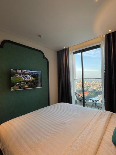 a bedroom with a large bed and a large window at Apec Mandala Phú Yên - Luxury Codotel in Phước Hậu