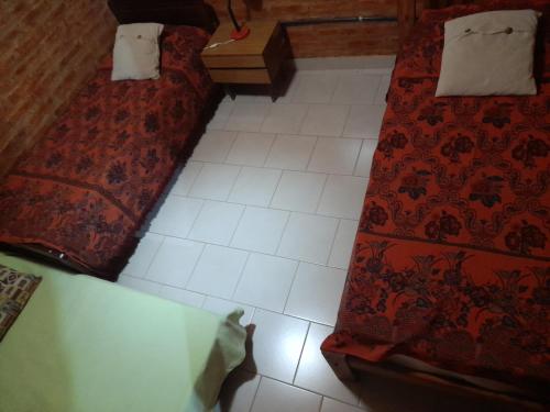 Un dormitorio con dos camas y suelo de baldosas. en Cabaña ParaLelo 1, en Viedma