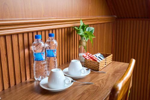 un tavolo in legno con due bottiglie d'acqua di Lotus Hotel Đà Lạt a Khu Chi Lăng