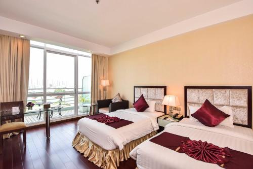 a hotel room with two beds and a balcony at Dara Airport Hotel in Phnom Penh