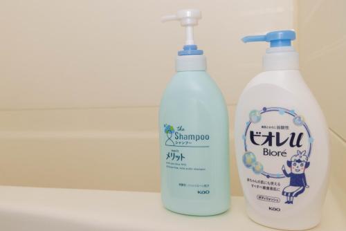 two bottles of cleaner sitting on a bathroom sink at Murasaki Good Place House in Chikushino