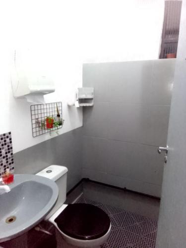 a bathroom with a toilet and a sink at Hostel Lize in Cumbica