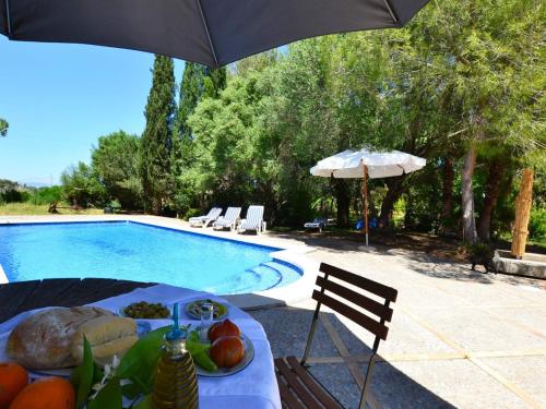 a table with a plate of food next to a swimming pool at Son Palanca with Private Pool & Gardens in Sineu