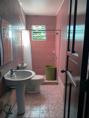 a pink bathroom with a toilet and a sink at CH Guest Inn in Cebu City
