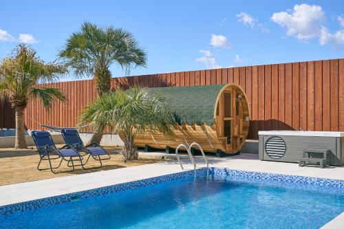 a swimming pool with a wooden circular house next to a building at VILLA SENSE kujukuri in Kujukuri