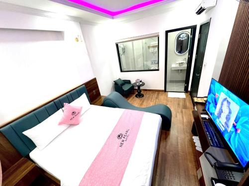 a room with a bed and a tv in it at New Pearl Hotel HCM in Ho Chi Minh City