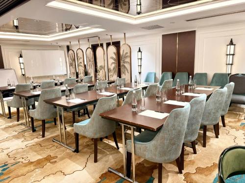 a conference room with tables and chairs and a whiteboard at Rue de L'amour Boutique Hotel Ha Noi in Hanoi