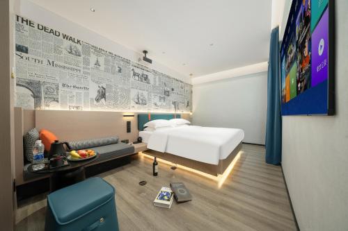 a hotel room with a bed and a tv at Lan Wan Hotel - Next to Huangsha Metro St ation -One cup of Free Cockt ail or Harbin Beer Per Room--Cha rgeable Airport Pick-up Service in Guangzhou