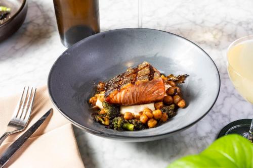 a bowl of food with meat and vegetables on a table at Kimpton - The Forum Hotel by IHG in Charlottesville