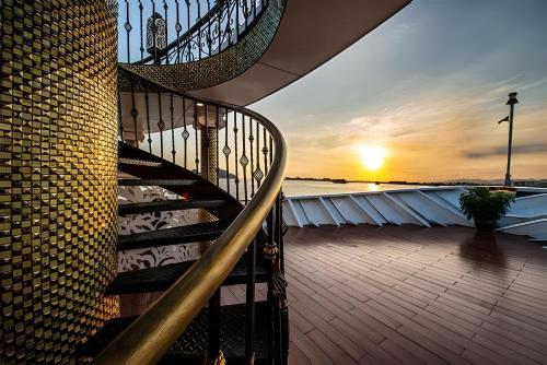 a spiral staircase on a cruise ship at sunset at Verdure Lotus Grandeur Cruise on Ha Long Bay in Ha Long