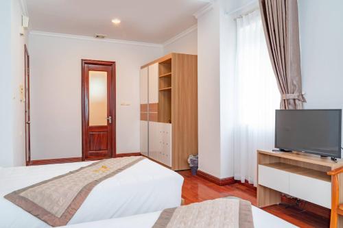 a bedroom with a bed and a flat screen tv at Private Balcony Hotel in Cat Ba